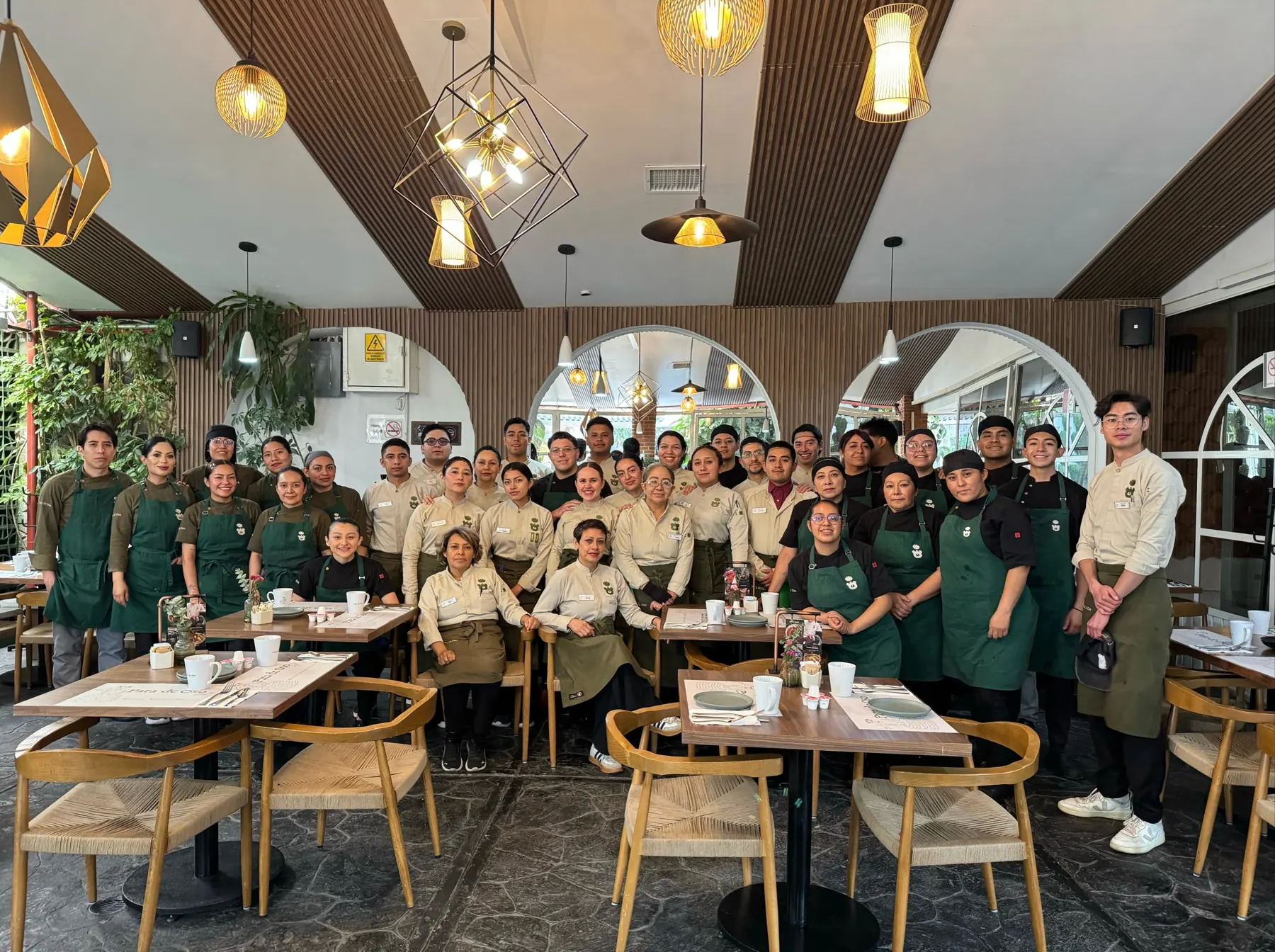 El equipo completo de Pata de Oso con sus mandiles verdes en el comedor