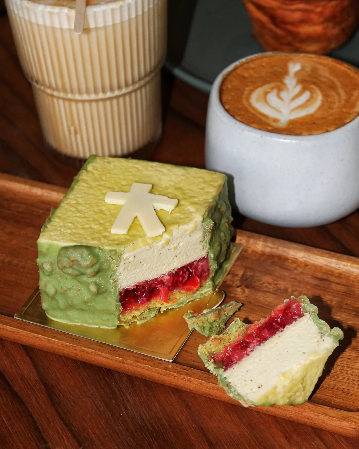 Postre de matcha cortado, con capa roja de compota